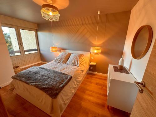 une petite chambre avec un lit et un miroir dans l'établissement Appartement spacieux et lumineux à Font Romeu, à Font-Romeu-Odeillo-Via