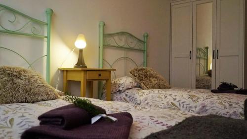 um quarto com duas camas e um candeeiro sobre uma mesa em Apartamento Estelas de Cantabria em Los Corrales de Buelna