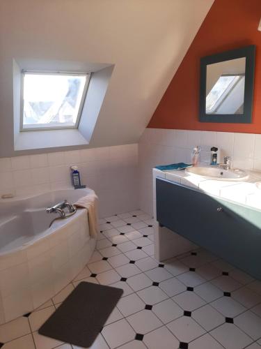 une salle de bain avec une baignoire et un lavabo dans l'établissement ESMAEL, à Larmor-Baden