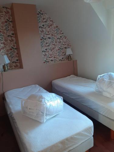 2 camas en una habitación con sábanas blancas en ESMAEL, en Larmor-Baden