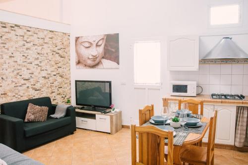 a living room with a couch and a table and a television at Casa Beta in Buenavista del Norte