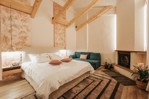 a bedroom with a large bed and a fireplace at Anerada Hotel in Kalavrita