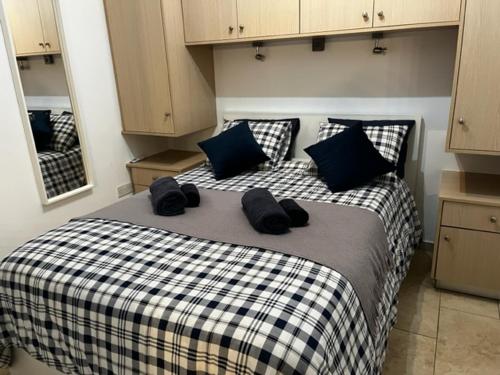 sypialnia z łóżkiem z niebieskimi i czarnymi poduszkami w obiekcie 2 Palaepaphos Gardens w mieście Kuklia