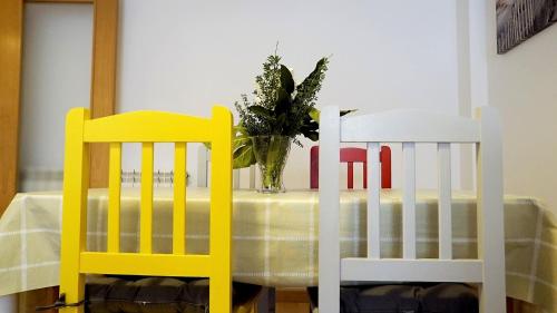 due sedie gialle e bianche sedute accanto a un tavolo di Apartamento Estelas de Cantabria a Los Corrales de Buelna