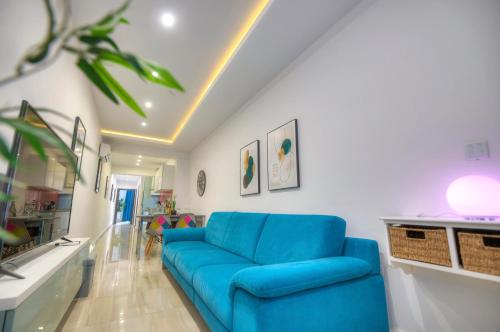 ein Wohnzimmer mit einem blauen Sofa in einem Zimmer in der Unterkunft Modern and bright 2bedroom with terrace SARD1-1 in St Julian's