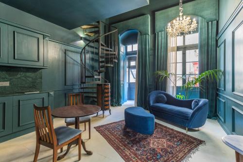 a living room with blue furniture and a spiral staircase at House of W in Valletta