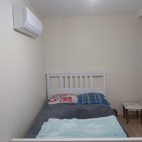 uma cama num quarto com uma parede branca em شقة بمنتجع مياتيرمال em Kaplıca