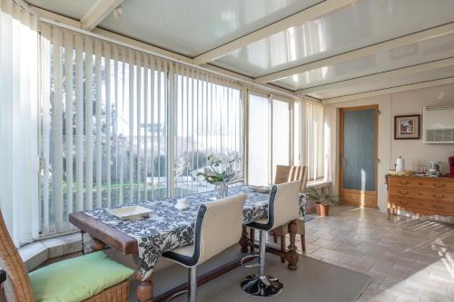 d'une salle à manger avec une table et quelques fenêtres. dans l'établissement Les Lauriers en Lubéron, à Cheval-Blanc