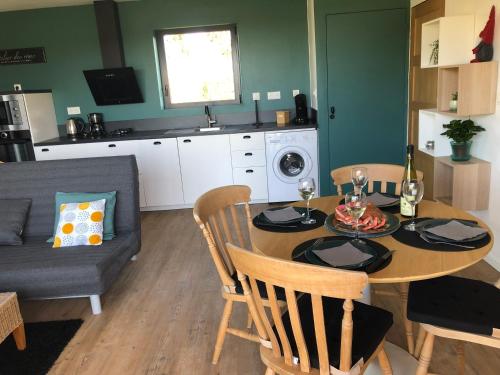 une cuisine et une salle à manger avec une table et des chaises dans l'établissement La Canopee, à Tonquédec