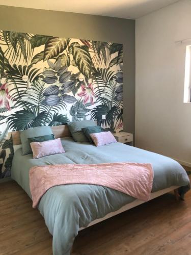 - une chambre avec un grand lit et du papier peint tropical dans l'établissement La Canopee, à Tonquédec