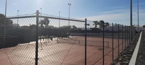 a tennis court with a chain link fence at Suite Bucica in Teguise
