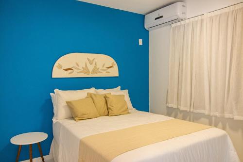 um quarto azul com uma cama e uma parede azul em Casa da Mãe - São Pedro da Aldeia em São Pedro da Aldeia