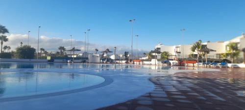 an empty swimming pool with buildings in the background at Suite Bucica in Teguise
