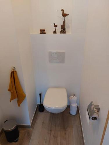 a white bathroom with a toilet and a sink at Aux six fontaines in Herve