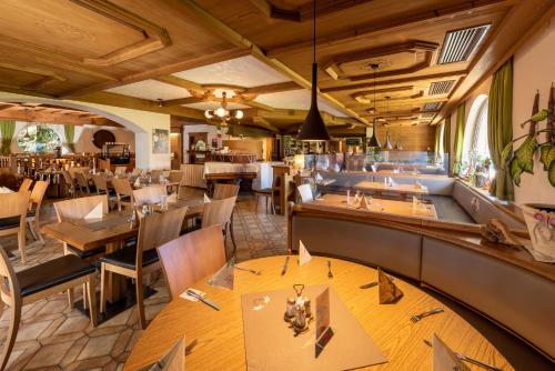 un restaurante con mesas y sillas de madera y un bar en Gasthof Enzian, en Tannheim
