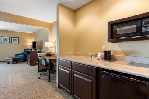 a hotel room with a desk and a microwave at Comfort Inn & Suites Bryant - Benton in Bryant