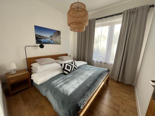 a bedroom with a bed and a large window at Apartmány Bobulky in Tatranská Lomnica