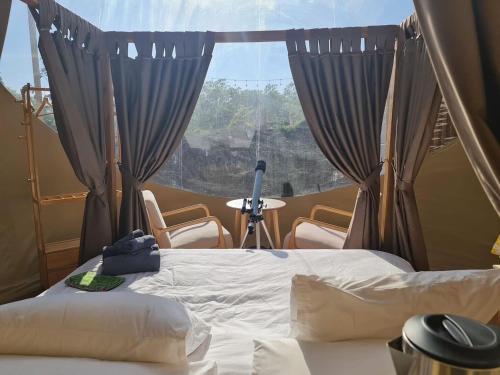 a bedroom with a bed and a window with curtains at The X10 Nordic Tent and Glamping Pool Villa Khaoyai เขาใหญ่ - SHA Certified in Ban Thung Sawang