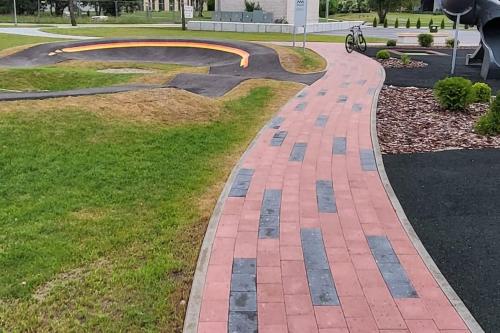 a brick walkway in a park with a skate park at Seaside_albatross in Ķesterciems