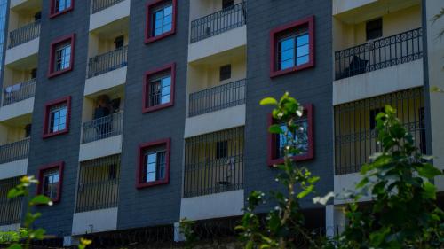 an apartment building with red and white windows at Cassabella Apartment, Opposite Metropark Hotel in Kisumu