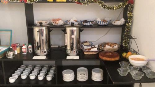 a shelf with two kettles and plates and other food at Hotel Regina in Formosa