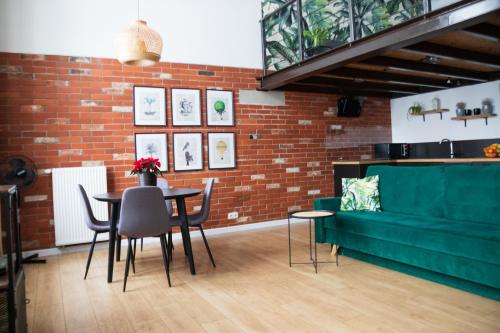 a living room with a green couch and a table at RedCity LOFT 303 in Żyrardów