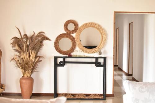 a console table with a mirror and a plant at Villa paisible proche des rizières in Antananarivo