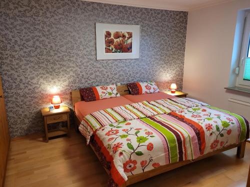 een slaapkamer met een bed en twee lampen op tafels bij Ferienwohnung Mohnblume in Rosdorf