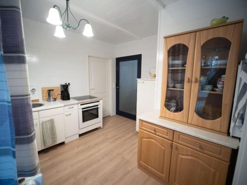 a kitchen with white cabinets and a wooden floor at Apartment Buckow in Buckow