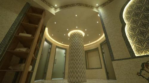 a bathroom with a column and a large mirror at Karvon-Saroy Hotel in Andijan