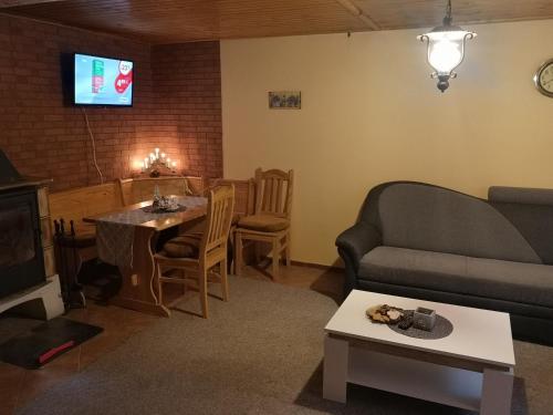 ein Wohnzimmer mit einem Sofa und einem Tisch in der Unterkunft M&M Chata Kokava Línia in Å oltÃ½ska