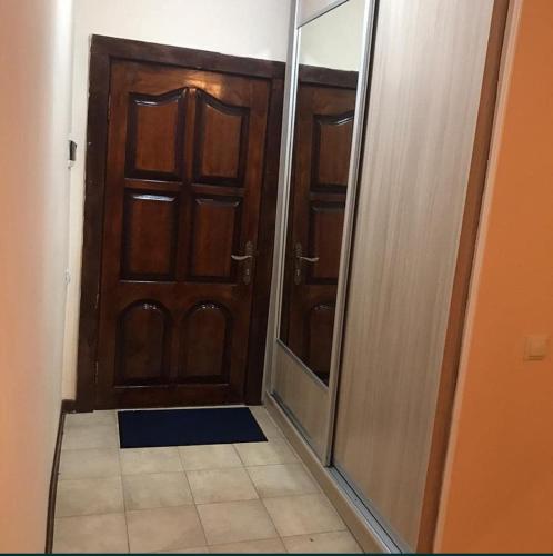 korytarz z drewnianymi drzwiami i lustrem w obiekcie Гостевой дом Самурук w mieście Atyrau