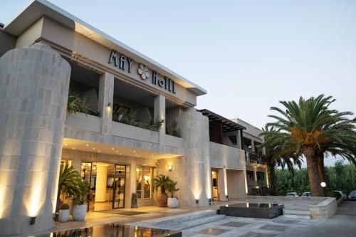 un edificio con palmeras delante en May Beach Hotel, en Rethymno