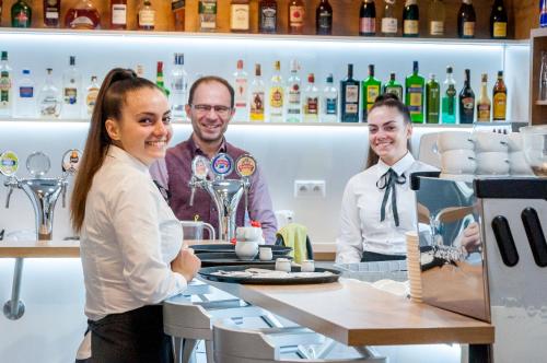 a group of people standing behind a counter in a bar at Salón MISSEN in Trenčianske Teplice