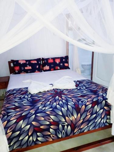 a bed with a colorful comforter in a room at Baobab Beach Vilanculos in Vilanculos