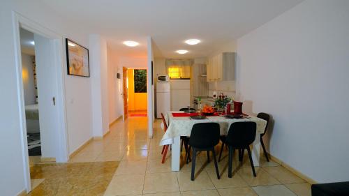 a kitchen and dining room with a table and chairs at La Arena sunflowers in Puerto de Santiago
