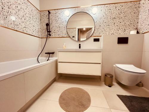 W łazience znajduje się toaleta z umywalką i lustro. w obiekcie Młociny Metro Apartment w Warszawie