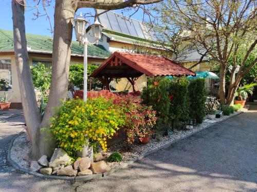 a garden with flowers and a gazebo at Hotel Oswaldo in Budapest