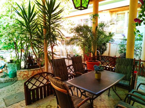 a patio with a table and chairs and plants at Hotel Oswaldo in Budapest