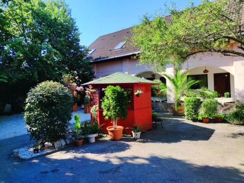 a house with a red shed with trees and plants at Hotel Oswaldo in Budapest