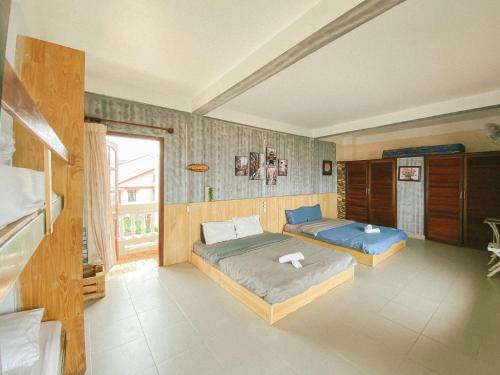 1 dormitorio con 2 camas y ventana en Nắng Hiên Nhà Villa - Homestay Đà Lạt, en Khu Chi Lăng