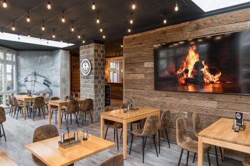 a restaurant with wooden tables and a fireplace at Villa Ludwigsburg in Kühlungsborn