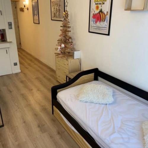 une chambre avec un lit et un sapin de Noël dans l'établissement Chez Greg les 2 ALPES, à Les Deux Alpes