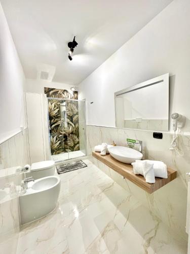 a white bathroom with two sinks and a mirror at Hangar Inn in Fiumicino