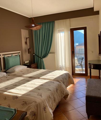 a hotel room with two beds and a balcony at Marianna's Home Accommodation in Karpenision