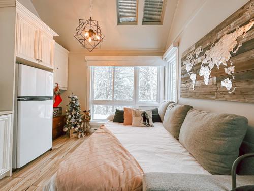 a living room with a couch and a christmas tree at Le Villageois by Gestion ELITE in Mont-Tremblant