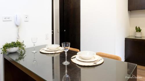 una mesa de comedor con copas de vino y platos en FH - Stunning apartment in Chico, en Bogotá