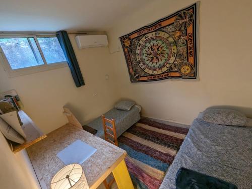 a room with a table and a couch and a clock on the wall at אשראם בכרמל - המקום של אורי in Dāliyat el Karmil