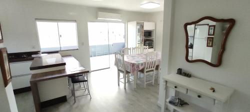 a kitchen and dining room with a mirror and a table at residencial pilati in Bombinhas