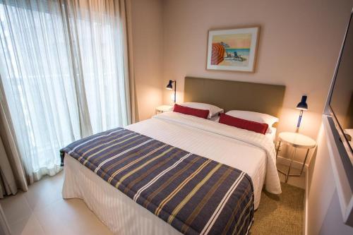 a bedroom with a large bed and a large window at Estanconfor Santos com Vista Mar 2 in Santos